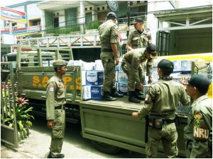 Petugas Satpol PP Kabupaten Bandung sedang mengangkut ratusan botol minuman keras berbagai merk ke atas mobil. Miras tersebut hasil sitaan dari sebuah toko di Jl. Siliwangi Ciwidey, Selasa (30/1). – foto: Lee