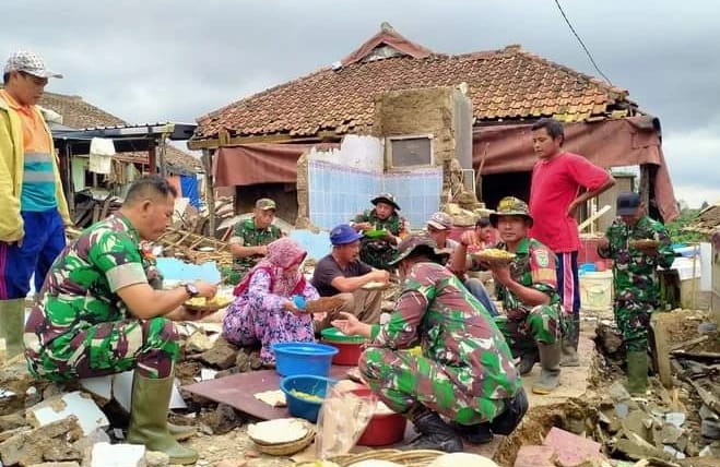 Babinsa dan Warga Makan Nasi Liwet Bersama Usai Kerja Bhakti Bersihkan Puing Rentuhan Rumah